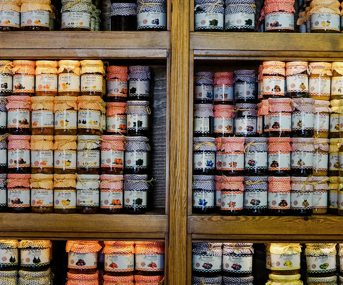 Shelves of finished preserve jars illustrating commercial packaging variety